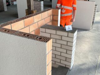LernenderMaurer EFZ beim QV-Probelauf in Landquart mit seinem gemauertem Übungsobjekt